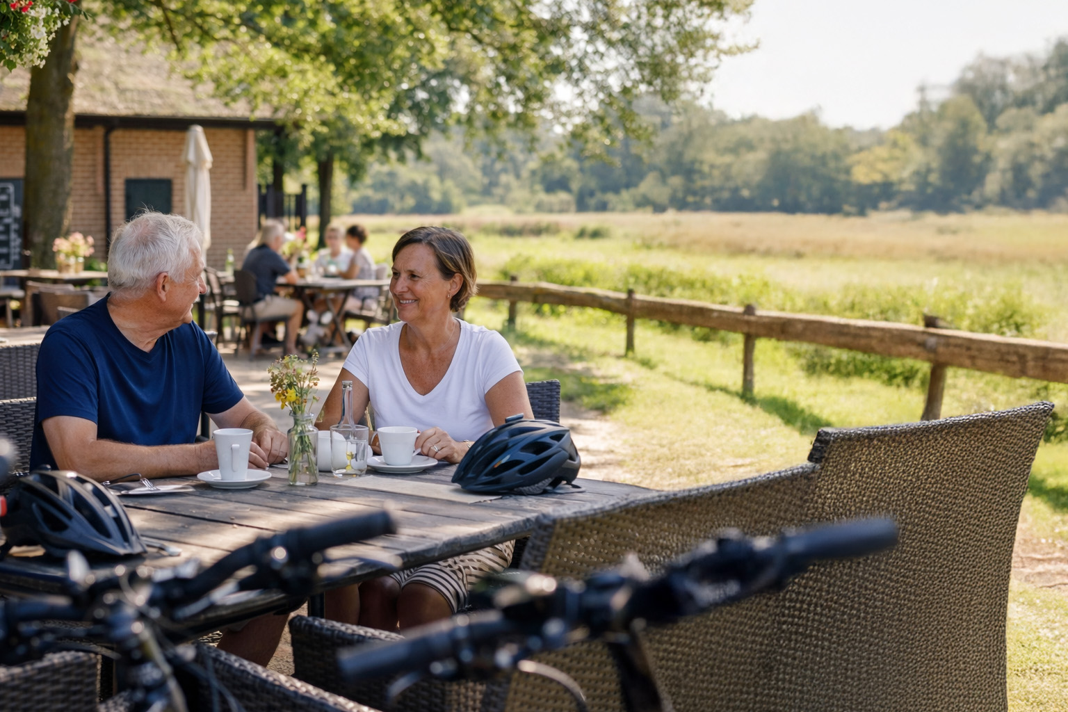 Koppel dat pauzeert tijdens een fietstocht in het Brabantse landschap met fietsen op de achtergrond